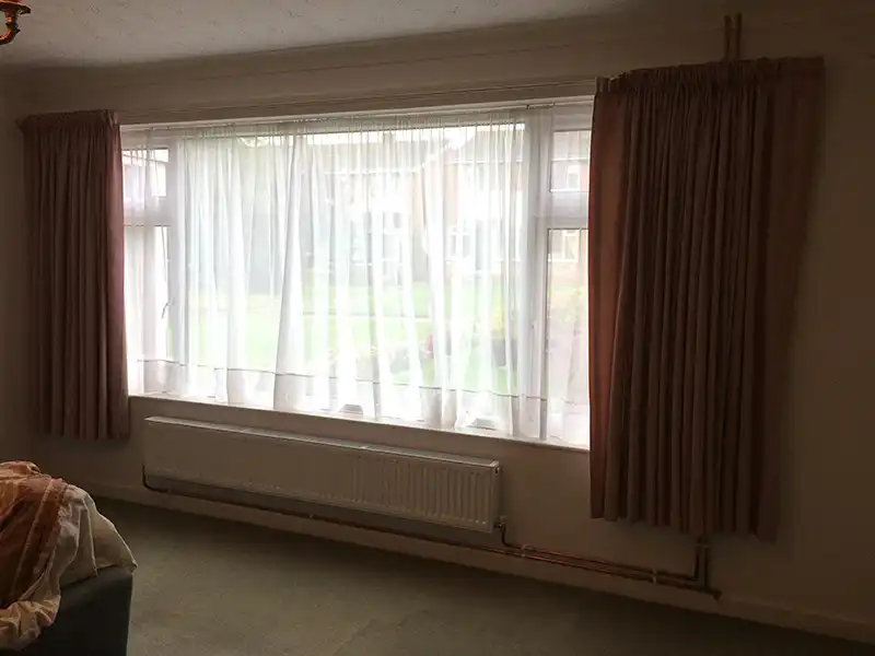 Complete new heating system with pipe drop hidden behind curtain